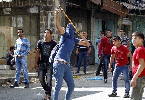 Un Palestinien utilise un lance-pierre lors d'affrontements avec les forces de sécurité israéliennes dans la ville d'Hébron en Cisjordanie.