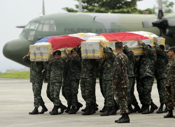  Les troupes des forces spéciales portent les cercueils recouverts du drapeau des militaires compatriotes tués dans des affrontements avec les rebelles musulmans.