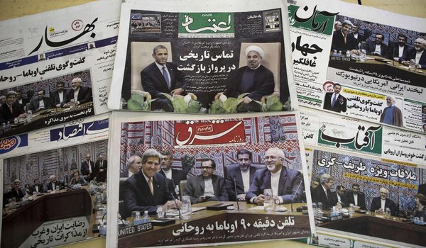 Une photo qui montre les  journaux iraniens avec des images représentant le président iranien Hassan Rouhani et le président américain Obama.