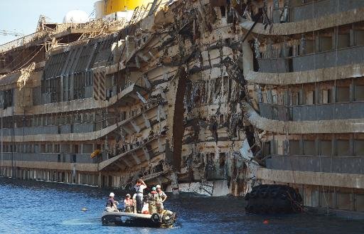 Les travailleurs de la société américaine Titan récupération et la firme italienne Micoperi inspecter l'épave du Concordia navire de croisière Costa après avoir été transporté hors de l'eau, dans le port de Giglio le 18 Septembre 2013