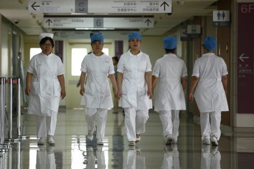 Illustration: un groupe d'infirmières se promène le long d'un couloir dans un hôpital de Pékin le 29 Juillet 2013.