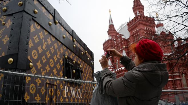 Une femme photographie la malle géante Louis Vuitton installée sur la place Rouge de Moscou, mercredi 27 novembre 2013
