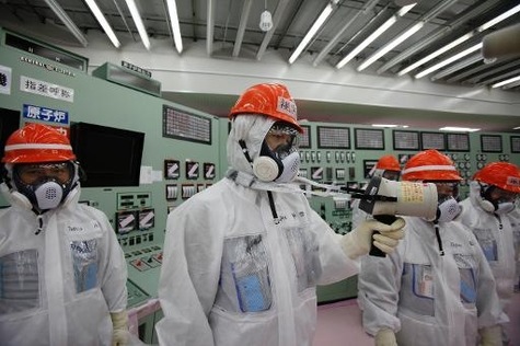Des employés de Tepco mesurent la radioactivité dans la salle de contrôle des unités 1 et 2 de la centrale atomique Fukushima Daiichi, le 10 mars 2014.